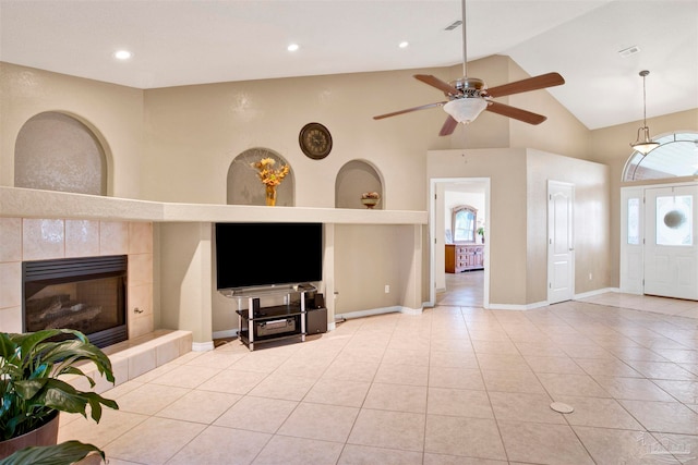 unfurnished living room with a healthy amount of sunlight, light tile patterned floors, a fireplace, and ceiling fan