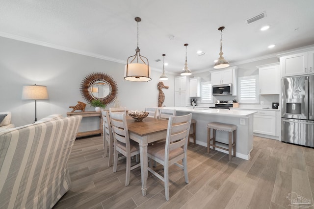 dining area with visible vents, ornamental molding, light wood-type flooring, and recessed lighting