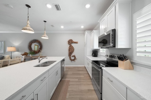 kitchen with white cabinetry, crown molding, a sink, appliances with stainless steel finishes, and visible vents