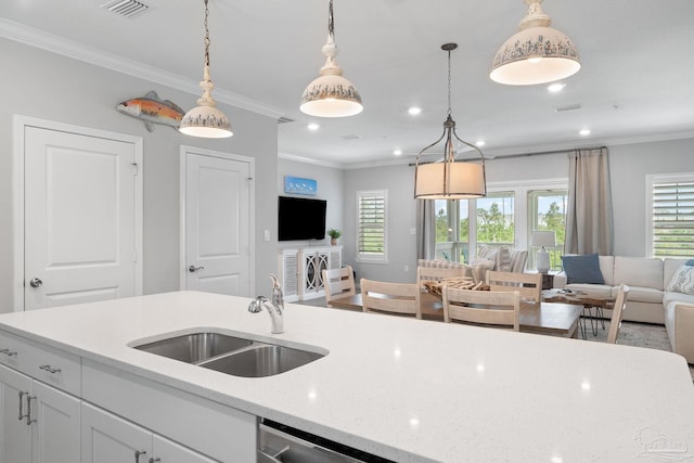kitchen with recessed lighting, white cabinets, a sink, open floor plan, and crown molding