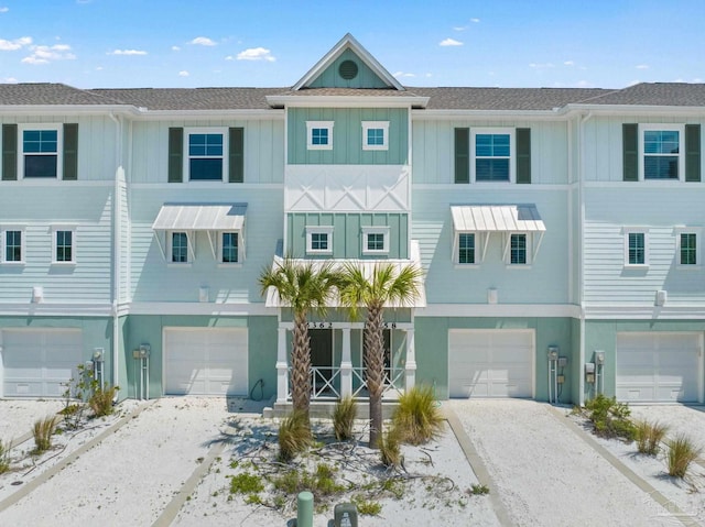 townhome / multi-family property featuring driveway, board and batten siding, stucco siding, and an attached garage