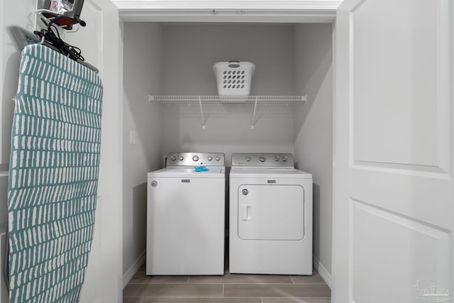 laundry area featuring wood tiled floor, independent washer and dryer, laundry area, and baseboards