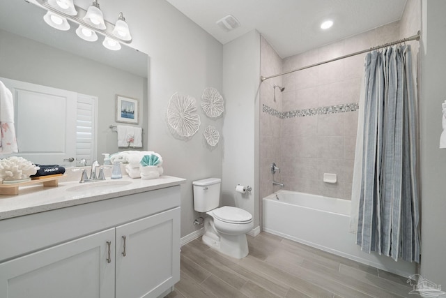 full bathroom with wood finished floors, shower / bath combo with shower curtain, toilet, vanity, and visible vents