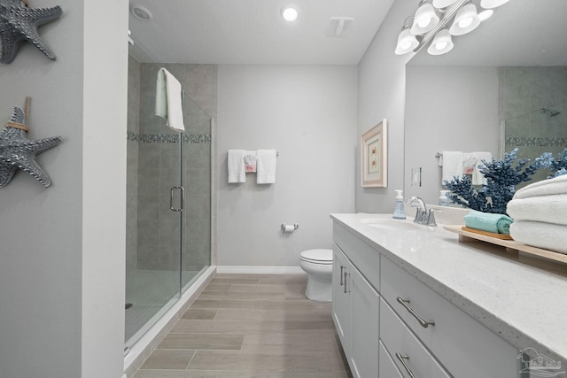 full bath with a shower stall, vanity, visible vents, baseboards, and wood finished floors
