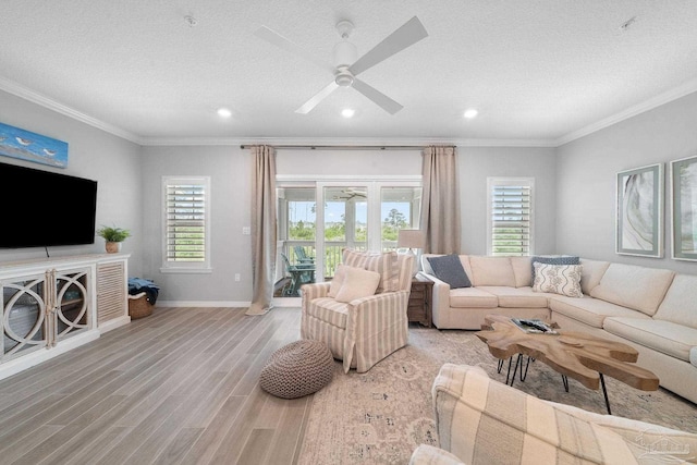 living room featuring baseboards, light wood-type flooring, crown molding, and recessed lighting