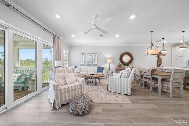 living room featuring ceiling fan, light wood-type flooring, recessed lighting, and ornamental molding