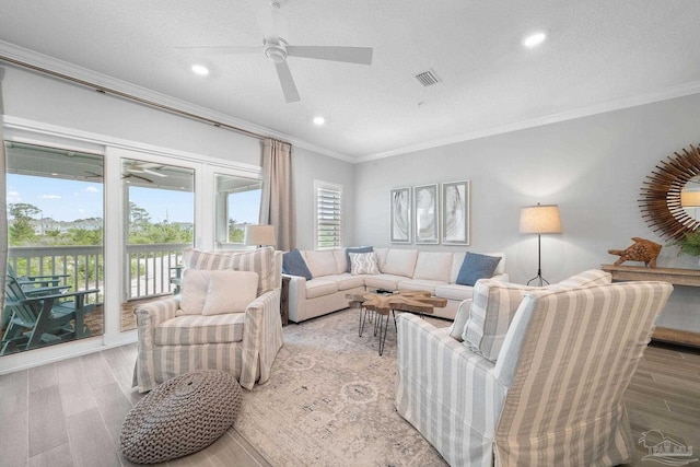 living area featuring recessed lighting, wood finished floors, ornamental molding, visible vents, and a ceiling fan