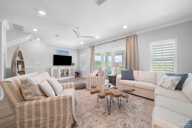living room with recessed lighting, wood finished floors, ornamental molding, ceiling fan, and visible vents