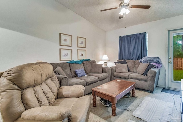 living room with light colored carpet, vaulted ceiling, a textured ceiling, and ceiling fan