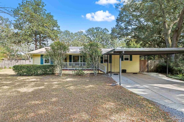 ranch-style house with covered porch, a carport, fence, and driveway