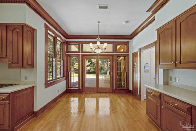 entryway featuring baseboards, ornamental molding, a chandelier, and light wood-style flooring