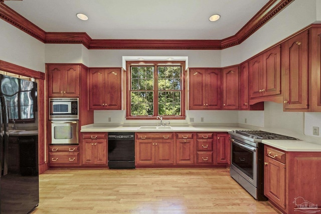 kitchen featuring a sink, light wood-type flooring, black appliances, light countertops, and ornamental molding