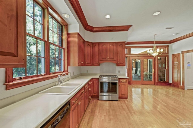 kitchen featuring a sink, a notable chandelier, light countertops, appliances with stainless steel finishes, and ornamental molding