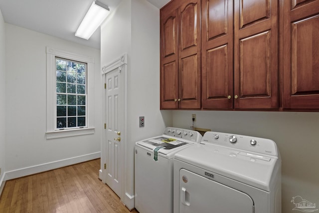 laundry room featuring cabinet space, light wood-type flooring, separate washer and dryer, and baseboards