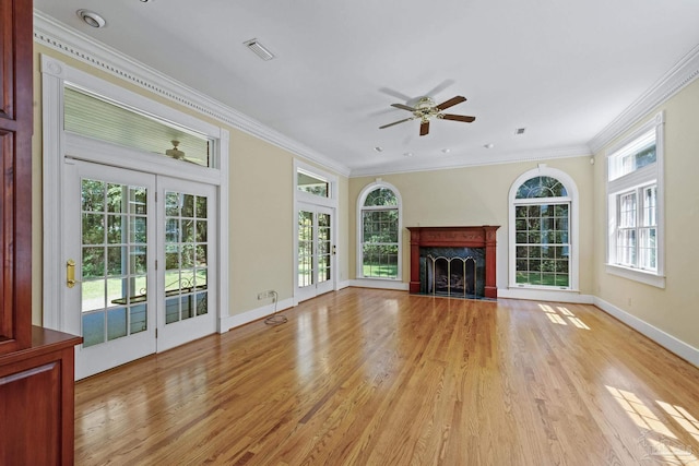 unfurnished living room with a premium fireplace, ceiling fan, light wood-style flooring, and crown molding