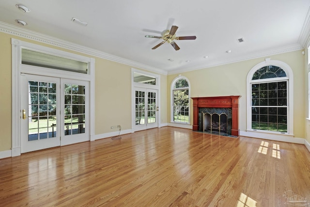 unfurnished living room featuring wood finished floors, a fireplace, visible vents, ceiling fan, and ornamental molding