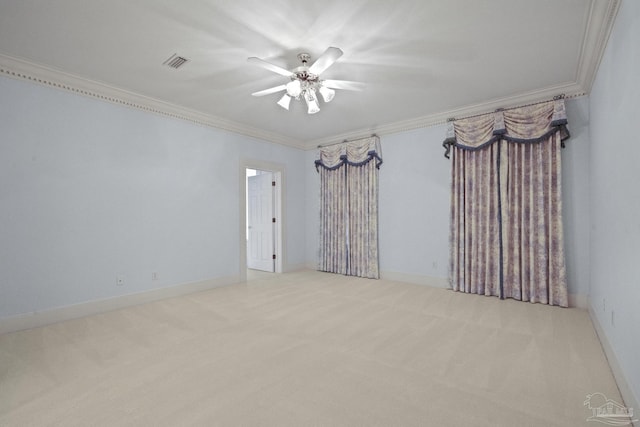 spare room with ceiling fan, visible vents, crown molding, and carpet
