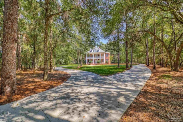 view of home's community with a yard and a view of trees