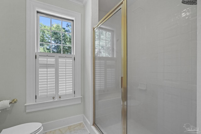 bathroom featuring a stall shower, toilet, and baseboards