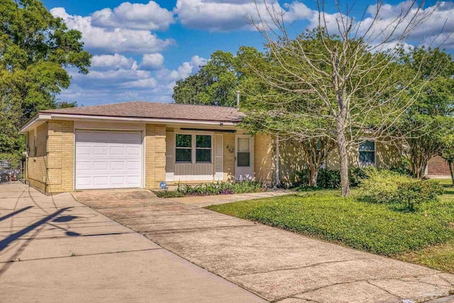 ranch-style home with concrete driveway, a front yard, brick siding, a garage, and a shingled roof