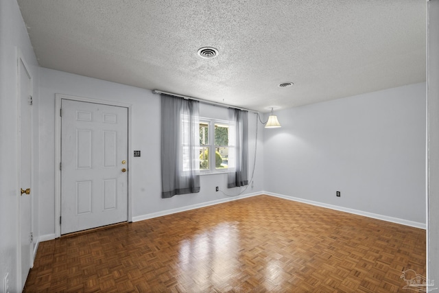 entryway featuring visible vents, baseboards, and a textured ceiling