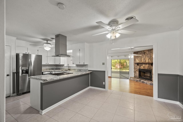 kitchen featuring stainless steel fridge with ice dispenser, a peninsula, island exhaust hood, and ceiling fan