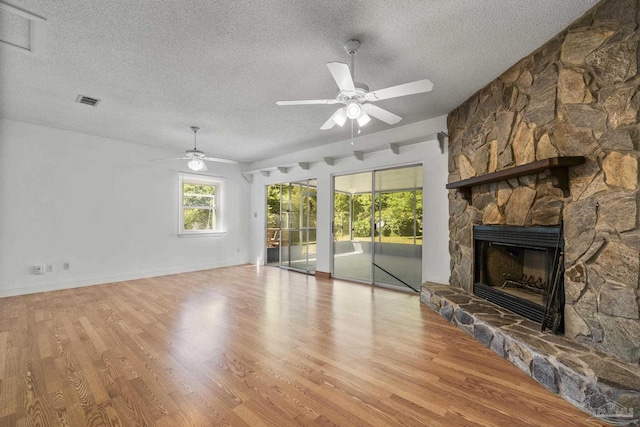 unfurnished living room with a textured ceiling, wood finished floors, and ceiling fan