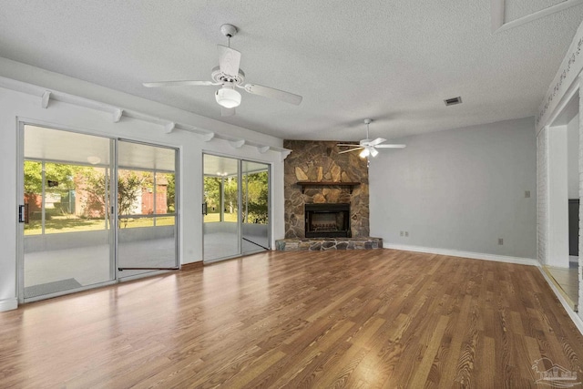 unfurnished living room featuring a wealth of natural light, a textured ceiling, and a ceiling fan