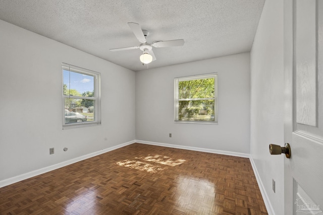spare room featuring plenty of natural light, baseboards, a textured ceiling, and ceiling fan