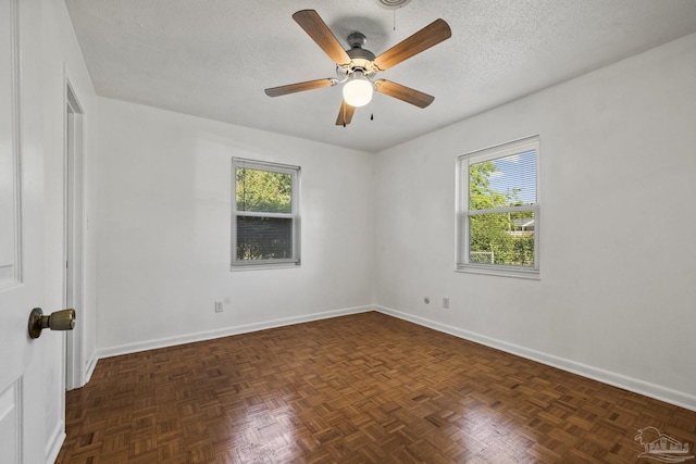 spare room featuring ceiling fan, baseboards, and plenty of natural light