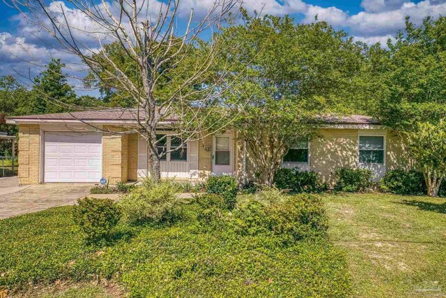 single story home featuring a garage, a front yard, brick siding, and driveway