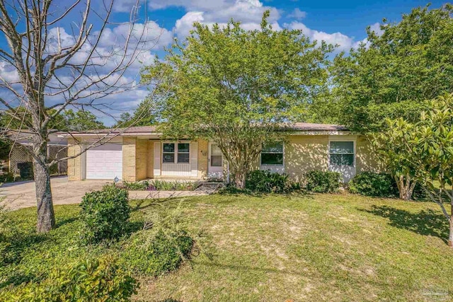ranch-style home with an attached garage, driveway, a front yard, and brick siding