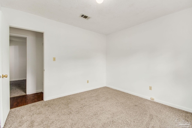 unfurnished room with carpet flooring and a textured ceiling