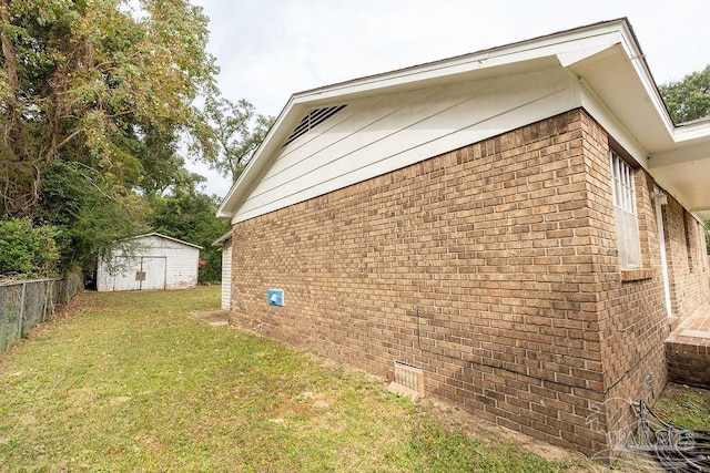 view of side of property with a lawn and a shed