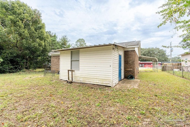 view of outbuilding with a lawn and a carport