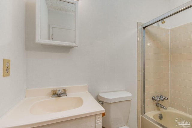 full bathroom with a textured ceiling, vanity, tiled shower / bath combo, and toilet