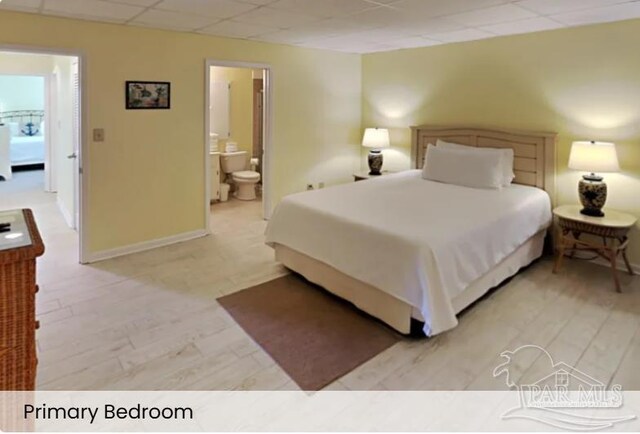 999 Ft Pickens Rd Unit 108, Pensacola Beach, FL 32561 - bedroom featuring a drop ceiling, ensuite bathroom, and baseboards