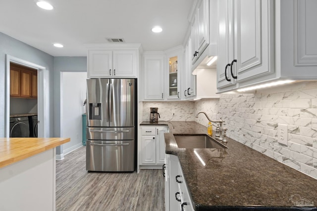 kitchen with wooden counters, sink, stainless steel fridge with ice dispenser, tasteful backsplash, and white cabinetry