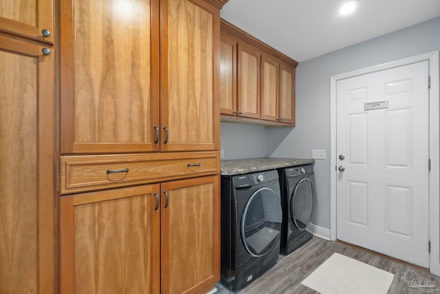 laundry area featuring cabinets, light wood-type flooring, and separate washer and dryer