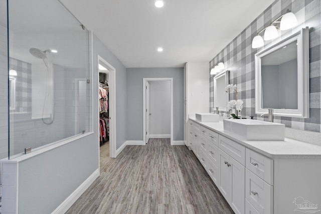 bathroom featuring tiled shower, vanity, and hardwood / wood-style flooring