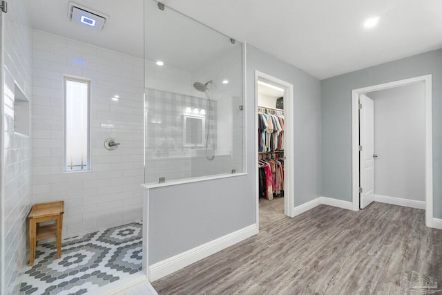 bathroom featuring tiled shower and wood-type flooring