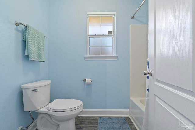 bathroom featuring shower / tub combination, wood-type flooring, and toilet