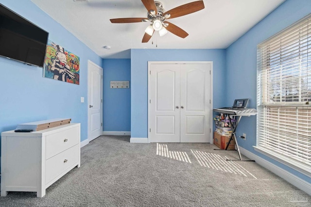 carpeted bedroom featuring a closet and ceiling fan