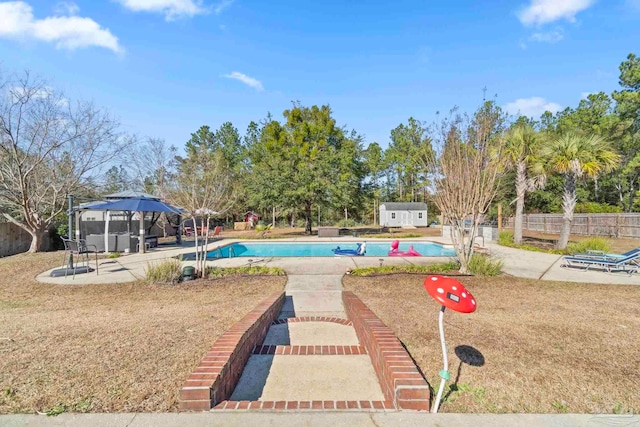 view of pool with a patio area and a shed