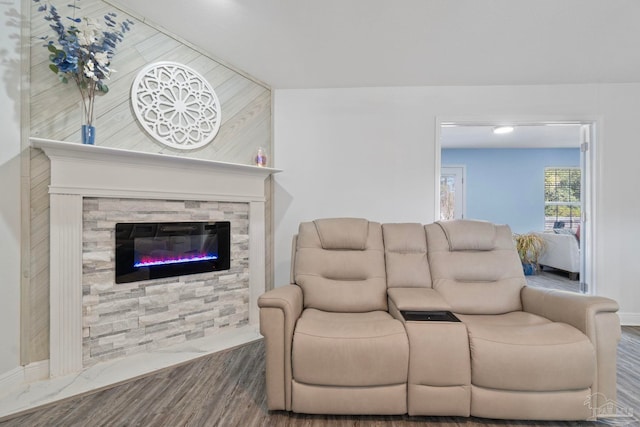 living room featuring wood-type flooring and a stone fireplace