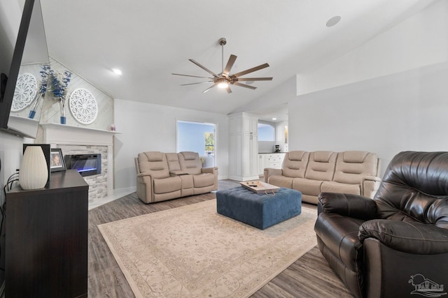 living room featuring a fireplace, dark hardwood / wood-style flooring, ceiling fan, and lofted ceiling