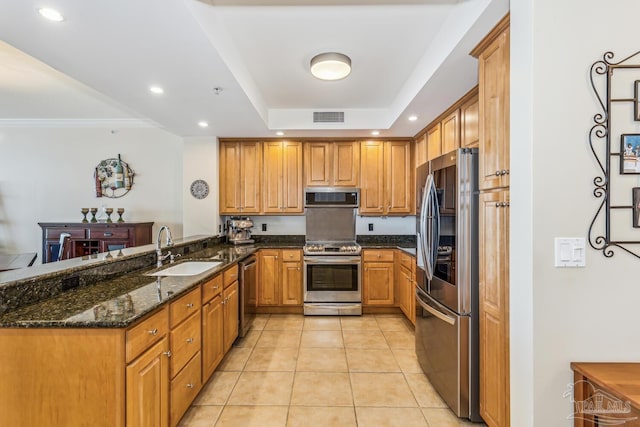 kitchen with kitchen peninsula, stainless steel appliances, sink, dark stone countertops, and light tile patterned flooring