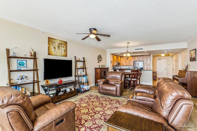 living room featuring ceiling fan with notable chandelier, light hardwood / wood-style floors, and ornamental molding