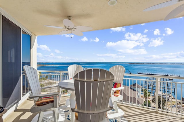 balcony with a water view and ceiling fan