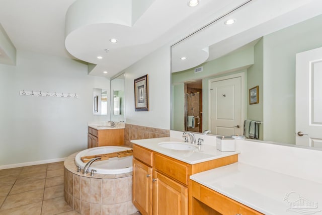 bathroom with tile patterned floors, vanity, and shower with separate bathtub